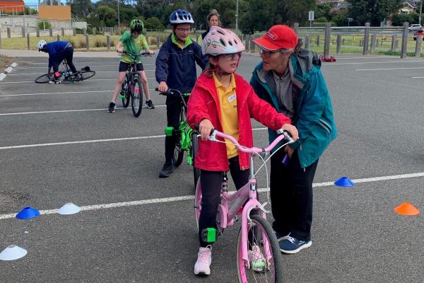 children lining up on bicycles learning how to ride