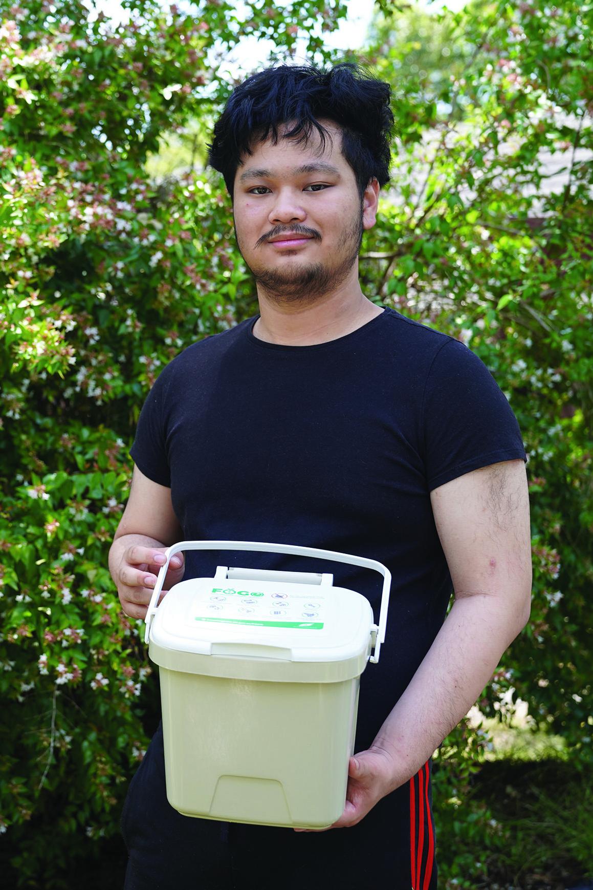 A young man in a black tshirt holds a light brown FOGO caddy