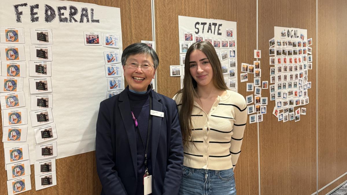 Councilor Anna Chen and MYAC co-chair Taylor standing in front of posters featuring the differing levels of government in Australia.