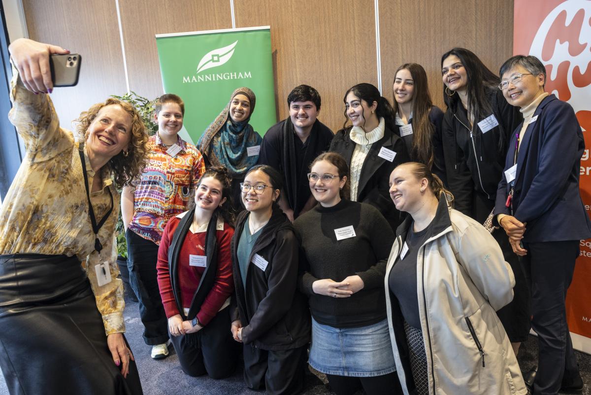 Woman takes a selfie with a group of 10 young people
