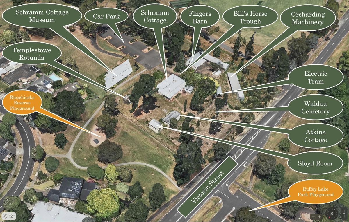 A labeled aerial view of Schramm Cottage Museum Complex showing buildings, playgrounds, car park, Victoria Street, and landmarks like Schramm Cottage, Fingers Barn, and Waldau Cemetery.