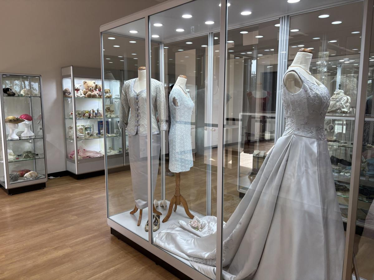 Historical dresses on display in a glass cabinet in the visitor centre.