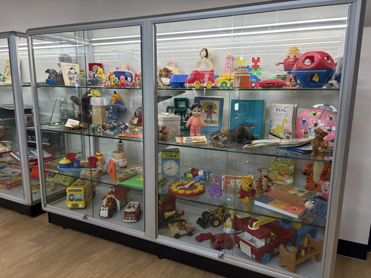A collection of historical toys on display in a glass cabinet at the new Schramms Cottage Museum and Visitor Centre.