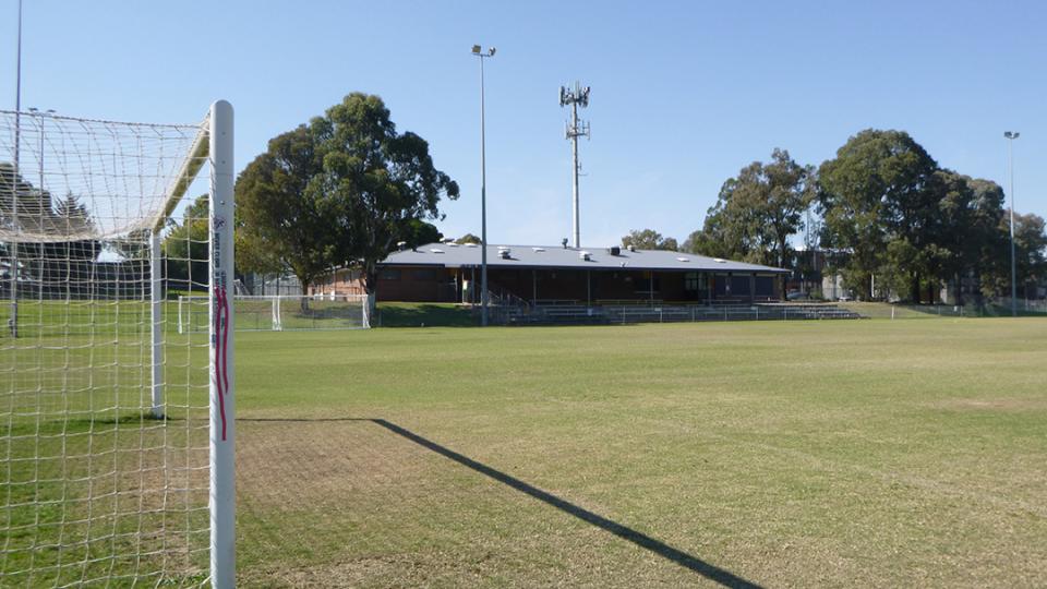 photo of a soccer field with the net in background an club centre in background