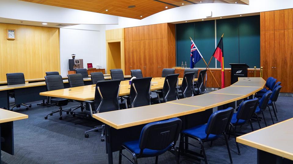 photo inside the council chamber showing the meeting table, the visitor gallery, lectern and both Australian and Aboriginal and Torres Straight Islander flags