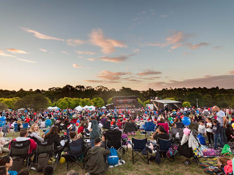 Large crowd of people seated watching outdoor event