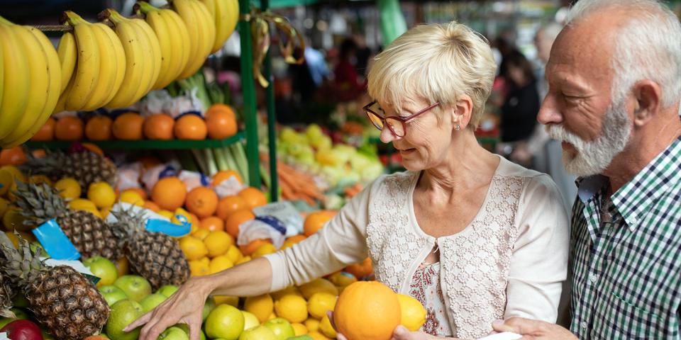 Older couple choosing produce in a fruit shop