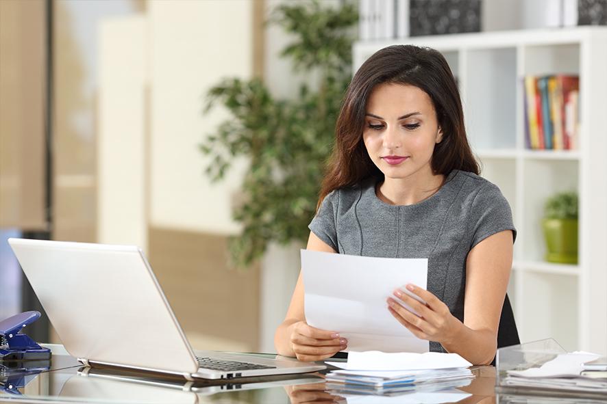 Woman reading letter at desk