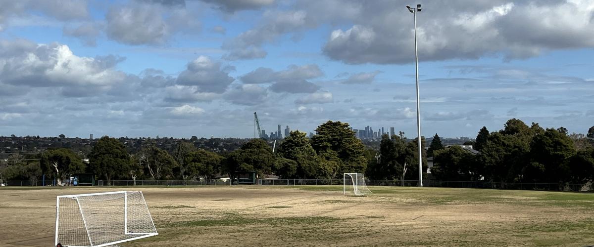 Oval with soccer goals at Timber Reserve with view of trees and city skyline