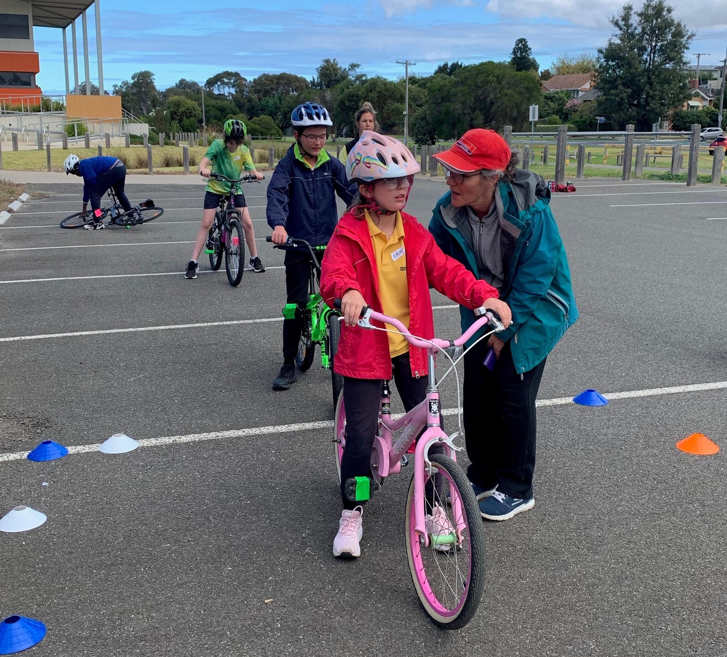 children lining up on bicycles learning how to ride