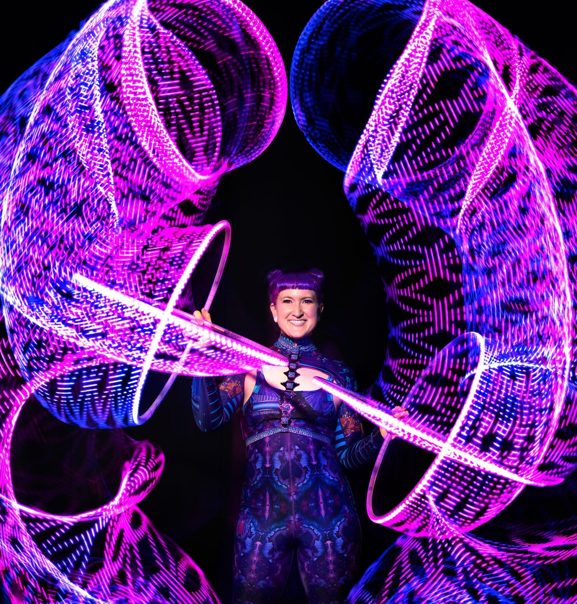 Light Hoop acrobatic dancer shapes around her from the light and movement in pinks and blues