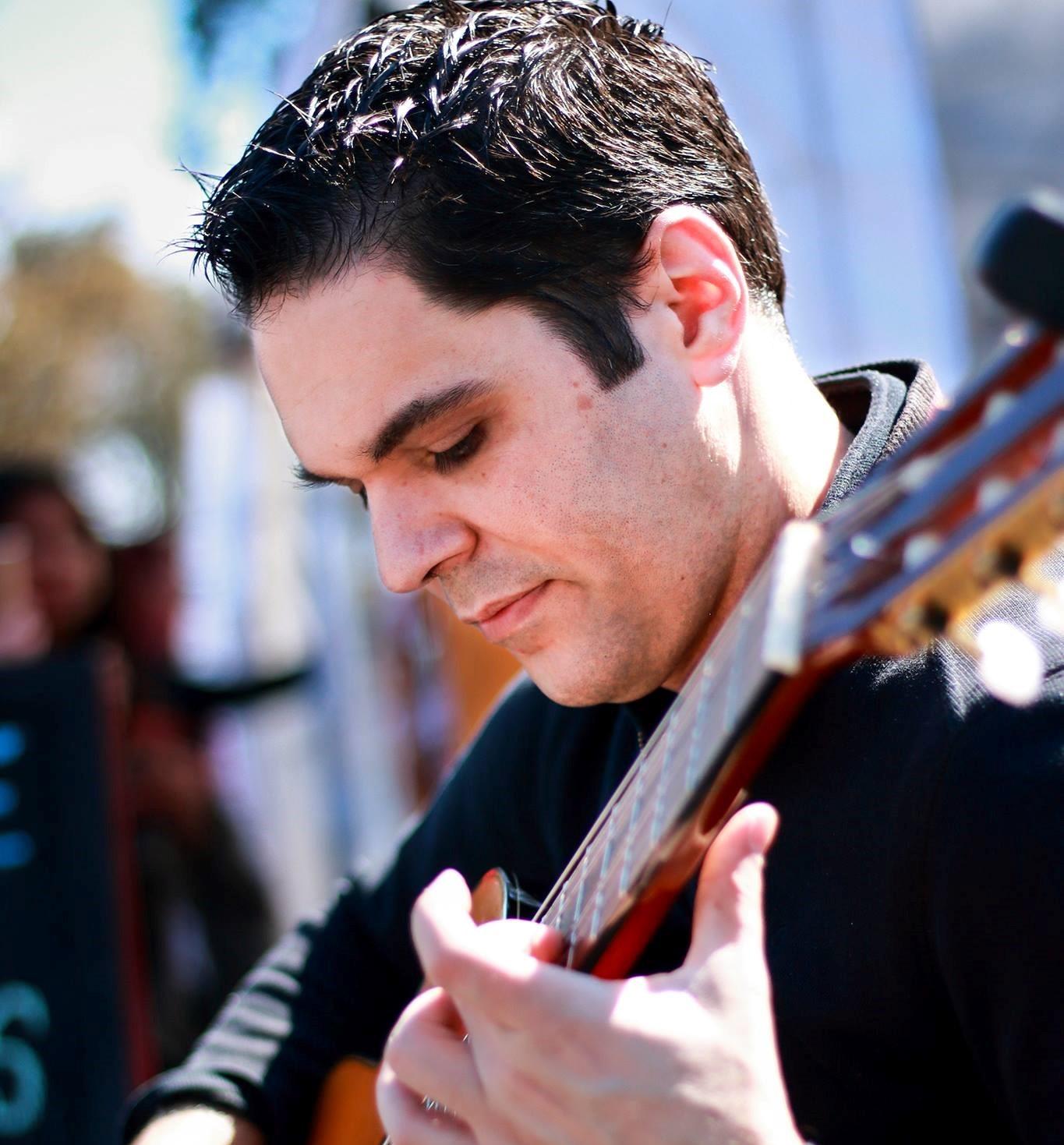 Man seated playing guitar