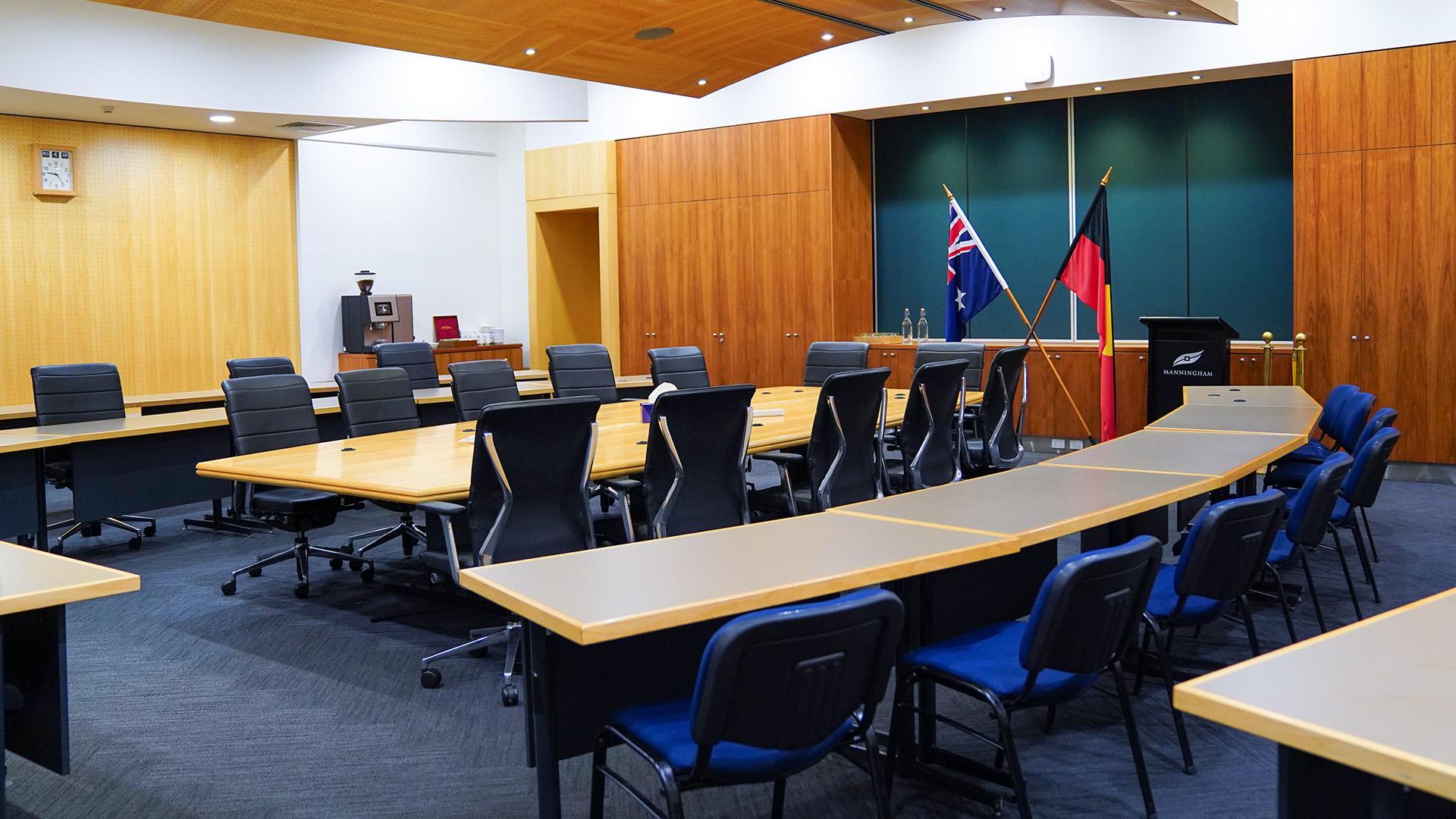 photo inside the council chamber showing the meeting table, the visitor gallery, lectern and both Australian and Aboriginal and Torres Straight Islander flags