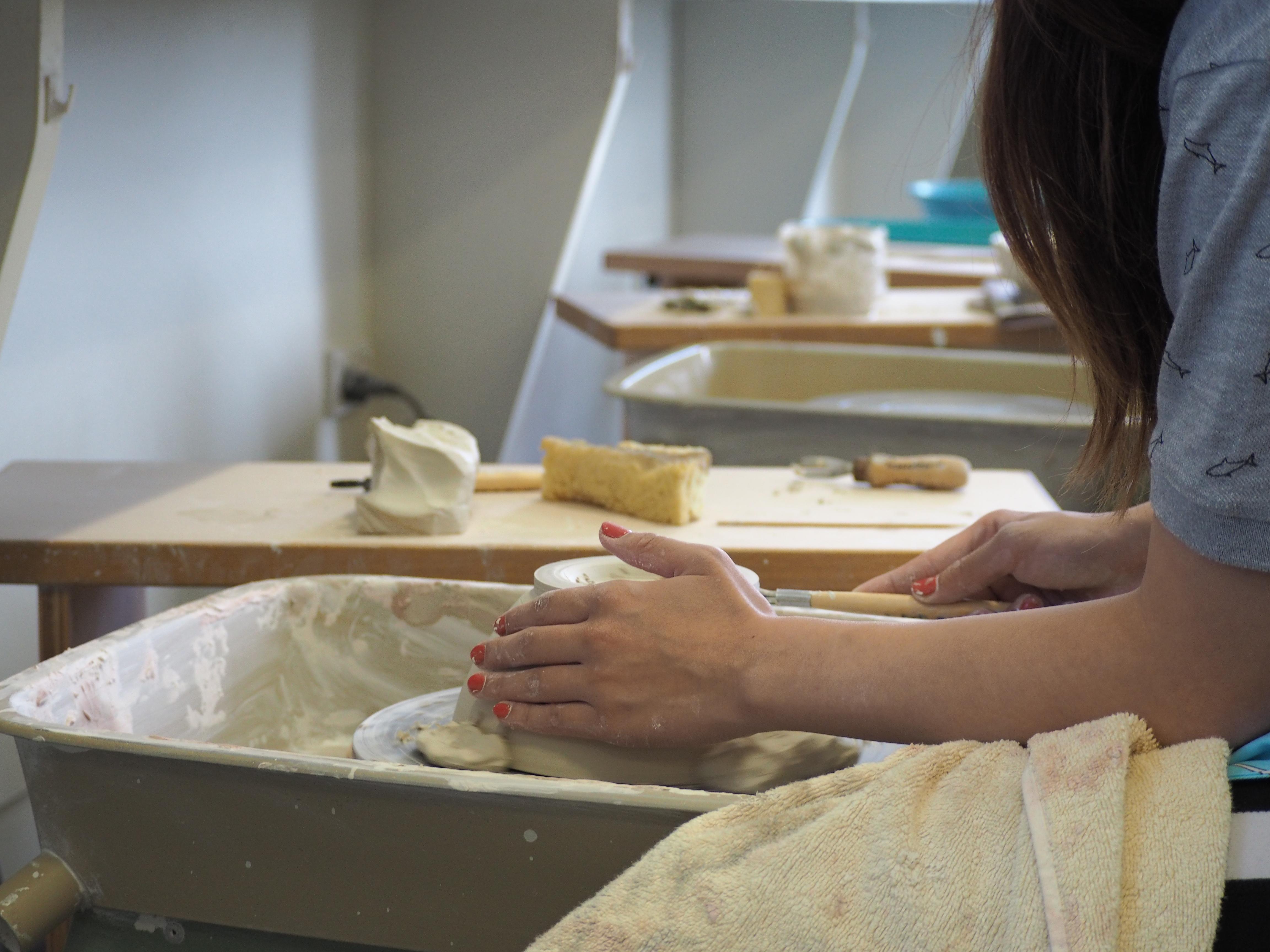 photograph of person throwing on the pottery wheel