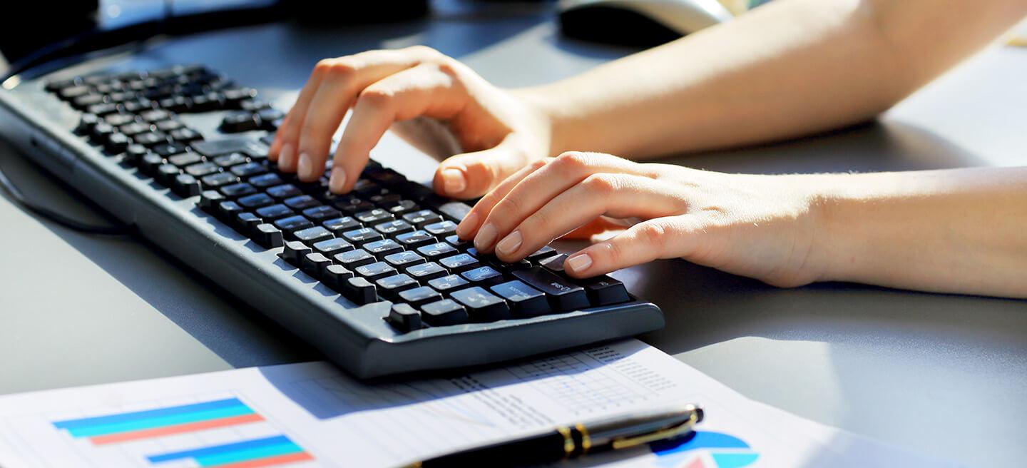 Closeup of hands typing on computer keyboard