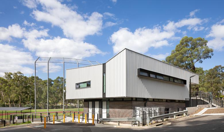 Modern clubhouse building with with baseball field in background