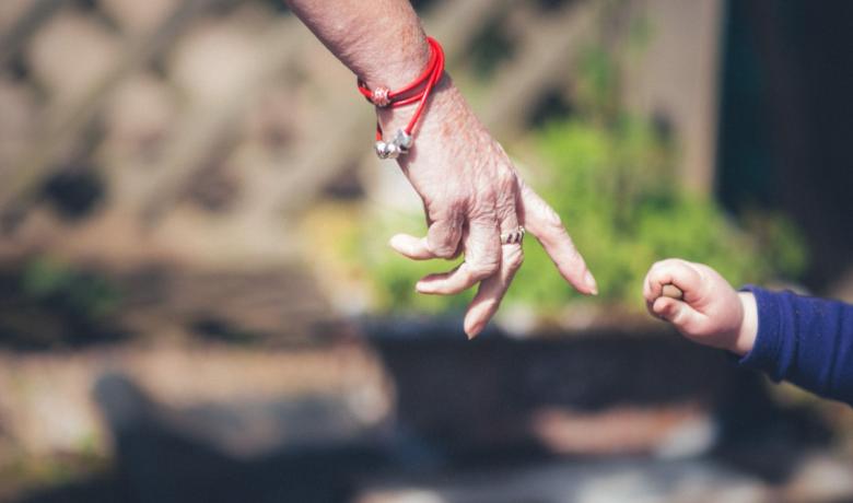 Grandmother and childs hands about to touch