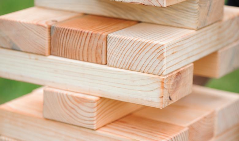 A small stack of Jenga blocks lined up neatly against a green background