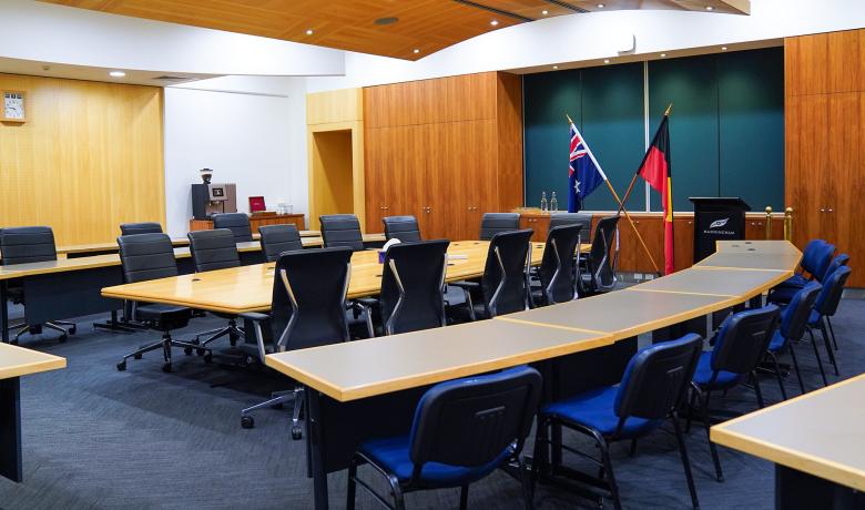 photo inside the council chamber showing the meeting table, the visitor gallery, lectern and both Australian and Aboriginal and Torres Straight Islander flags
