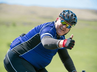 Man riding a bike smiling at camera