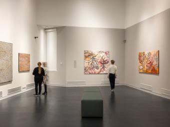 Three women in the Manningham Art Gallery viewing paintings from the Painted Country exhibition.