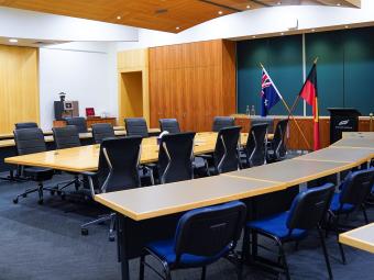 photo inside the council chamber showing the meeting table, the visitor gallery, lectern and both Australian and Aboriginal and Torres Straight Islander flags