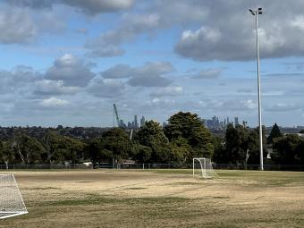 Oval with soccer goals at Timber Reserve with view of trees and city skyline