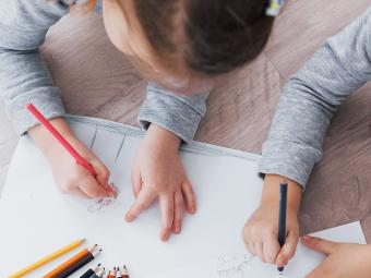 kids drawing while laying on floor