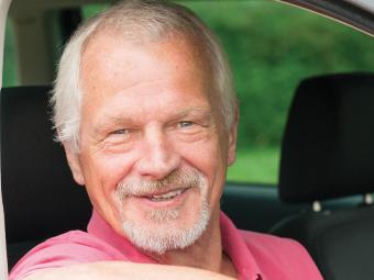 man in car smiling at camera