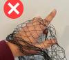 Illegal fruit tree netting, showing a finger poking through the wide mesh